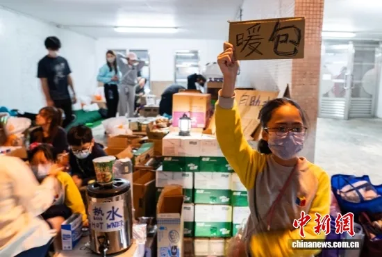 11月27日晚,青少年参与为火灾受影响市民提供热水、暖包等物资帮助。中新社记者 侯宇 摄 11月27日晚,青少年参与为火灾受影响市民提供热水、暖包等物资帮助。中新社记者 侯宇 摄