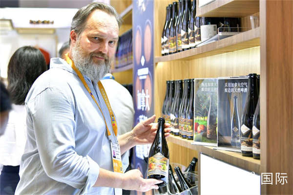 一名展商正在展示产自加拿大的苹果啤酒。人民网记者 任峰涛摄