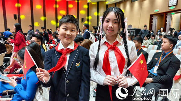 中越两国年龄最小的演讲者手拿对方国家的旗帜,“跨国”合影。人民网记者 刘刚摄